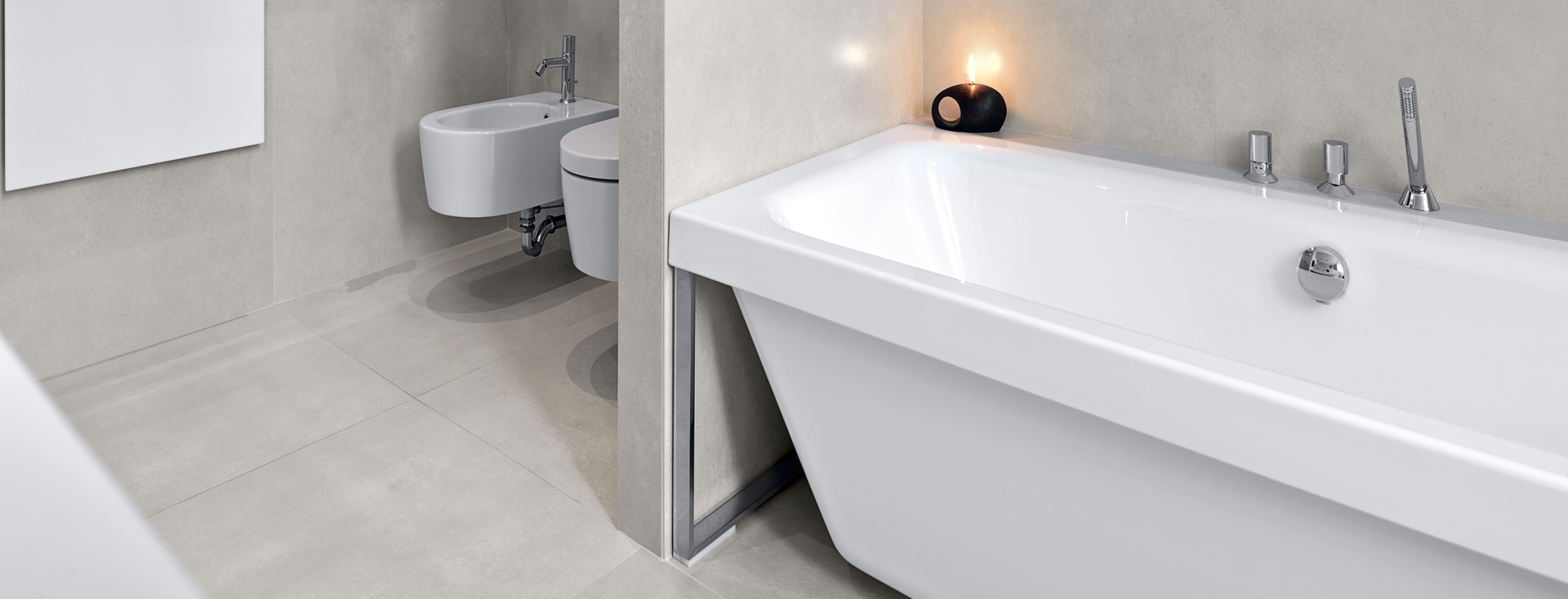 Modernes, geliestes Badezimmer mit weißer Badewanne, Toilette, Schrank und einem schwarzen Handtuch am Handtuchhalter