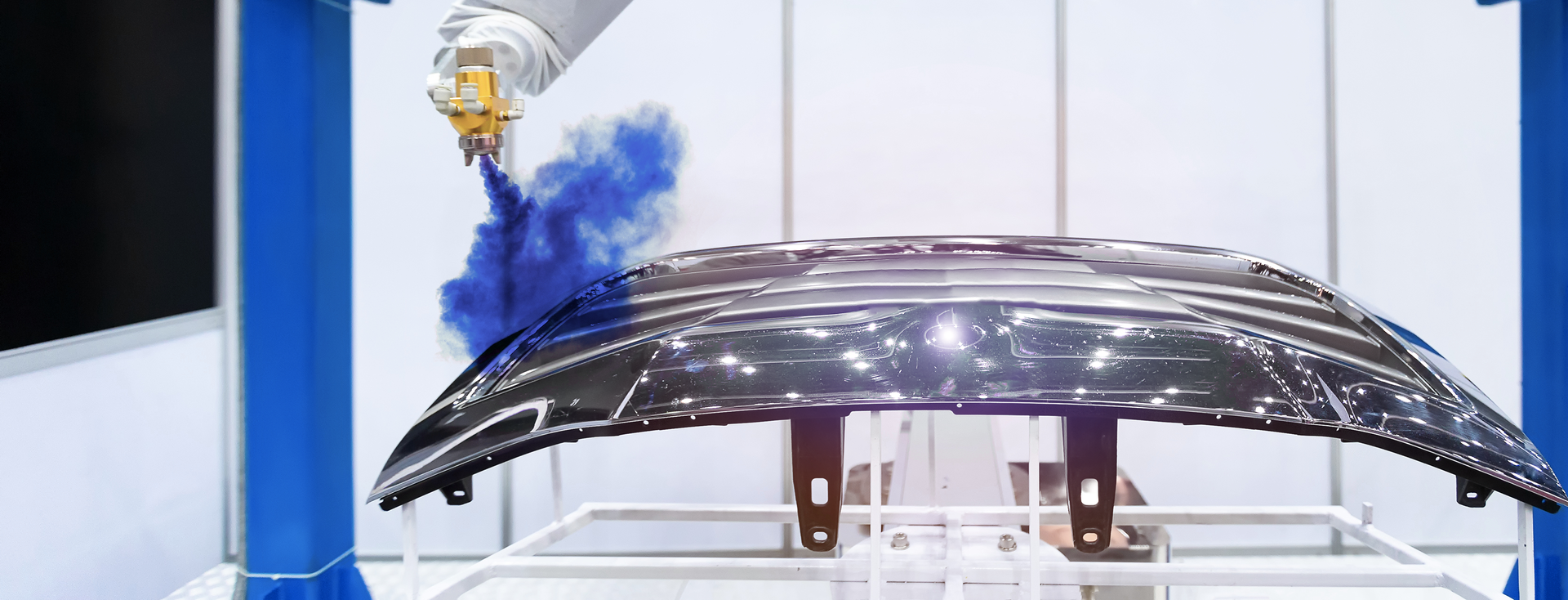 Industrieroboterarm lackiert eine Motorhaube mit blauer Farbe