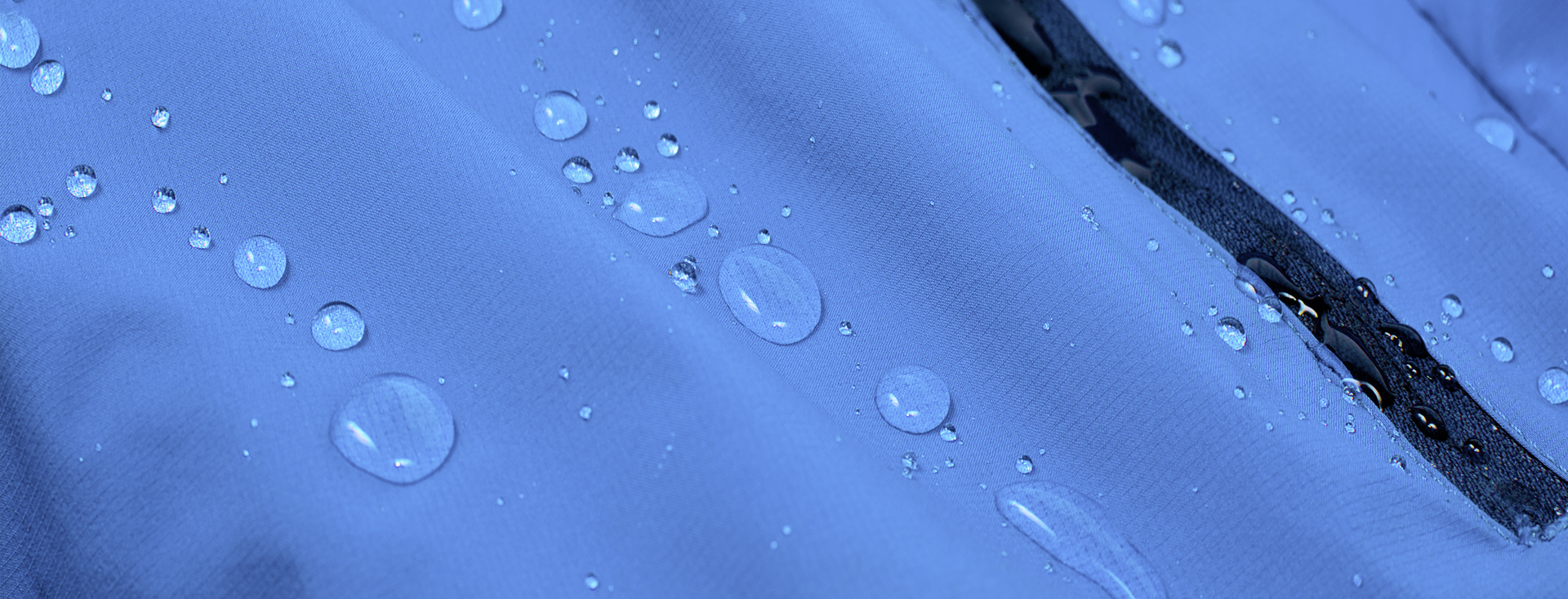 water droplets rolling off a blue rain jacket