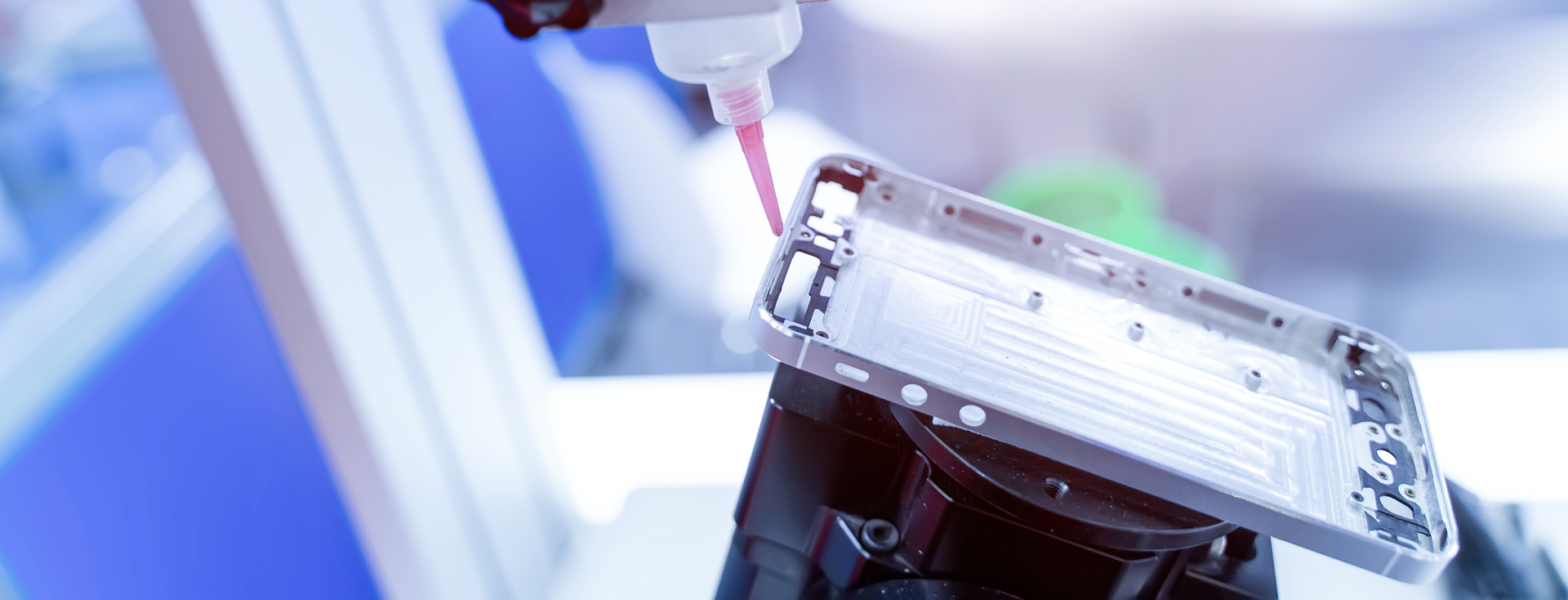 Automatic dispensing system applies adhesive to a cell phone frame