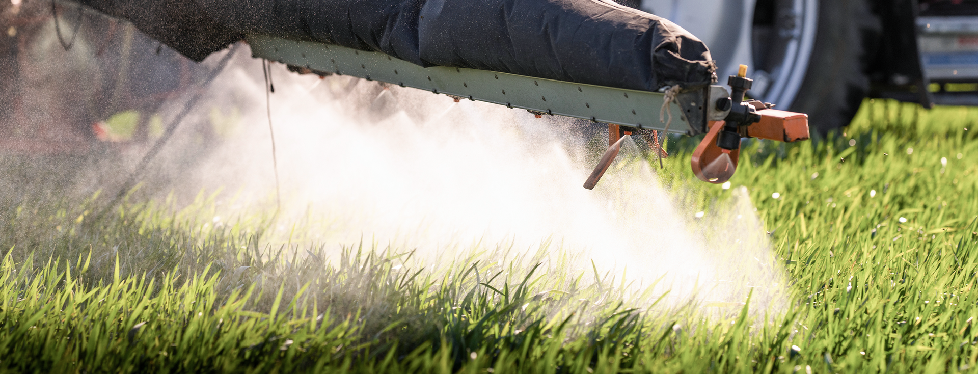 close-up of a tractor spraying a meadow with pesticides